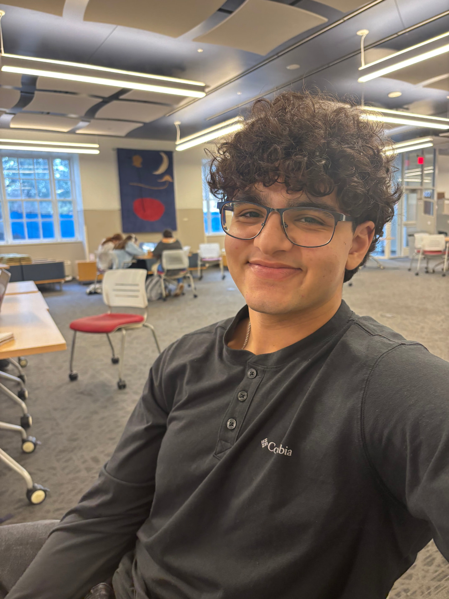 Seif Eid, founder of OpenEars, smiling in a campus study space